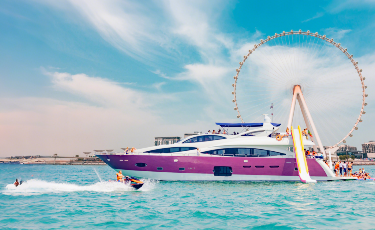 Tourists rent a luxury yacht from Sky Walker Yachts to enjoy yacht ride & slide and jet skiing in the waters off Ain Dubai